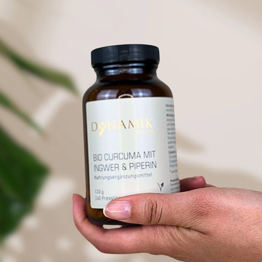 Brauner Glasbehälter mit DynamikPlus "Bio Curcuma mit Ingwer & Piperin" Etikett und schwarzem Drehverschluss