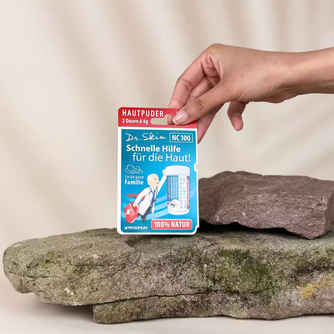 Blaue Verpackung mit "Dr.Skin Hautpuder" Druck und Arztabbildung
