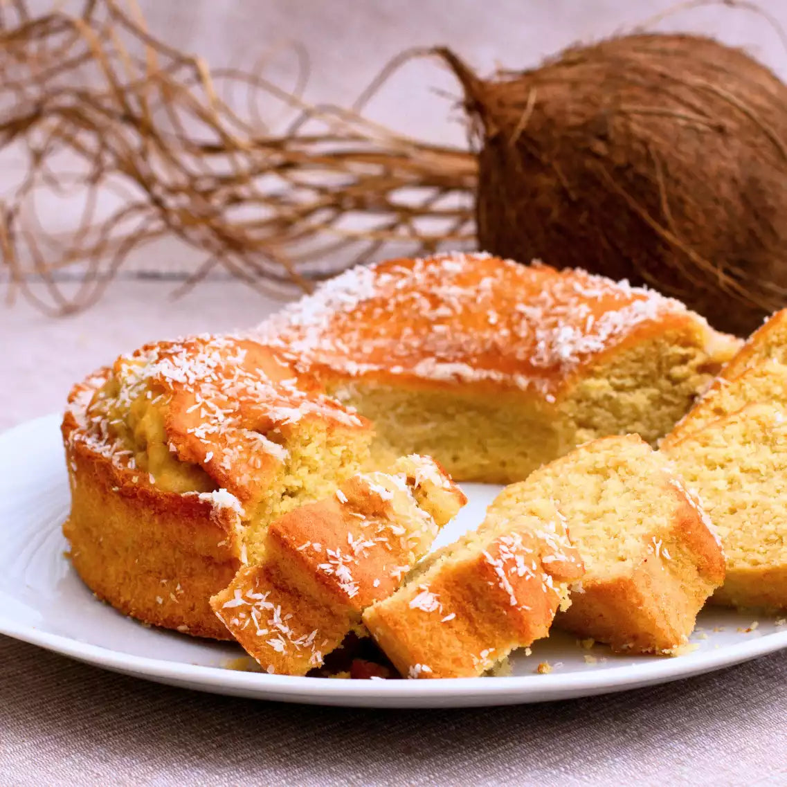 Kuchen mit Kokosrapseln und einer Kokosnuss im Hintergrund