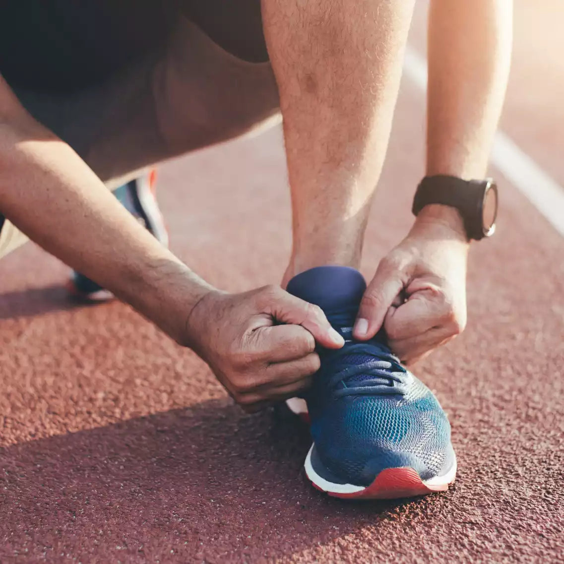 Sportler welcher sich die Schuhe bindet