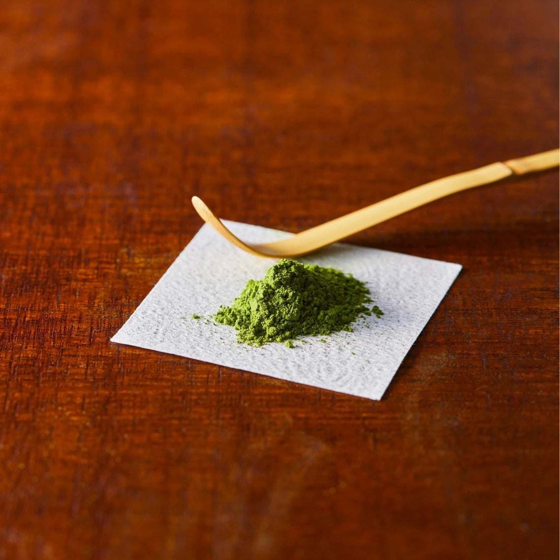 Matcha Löffel mit kleinem Matcha Haufen auf weißem Papier