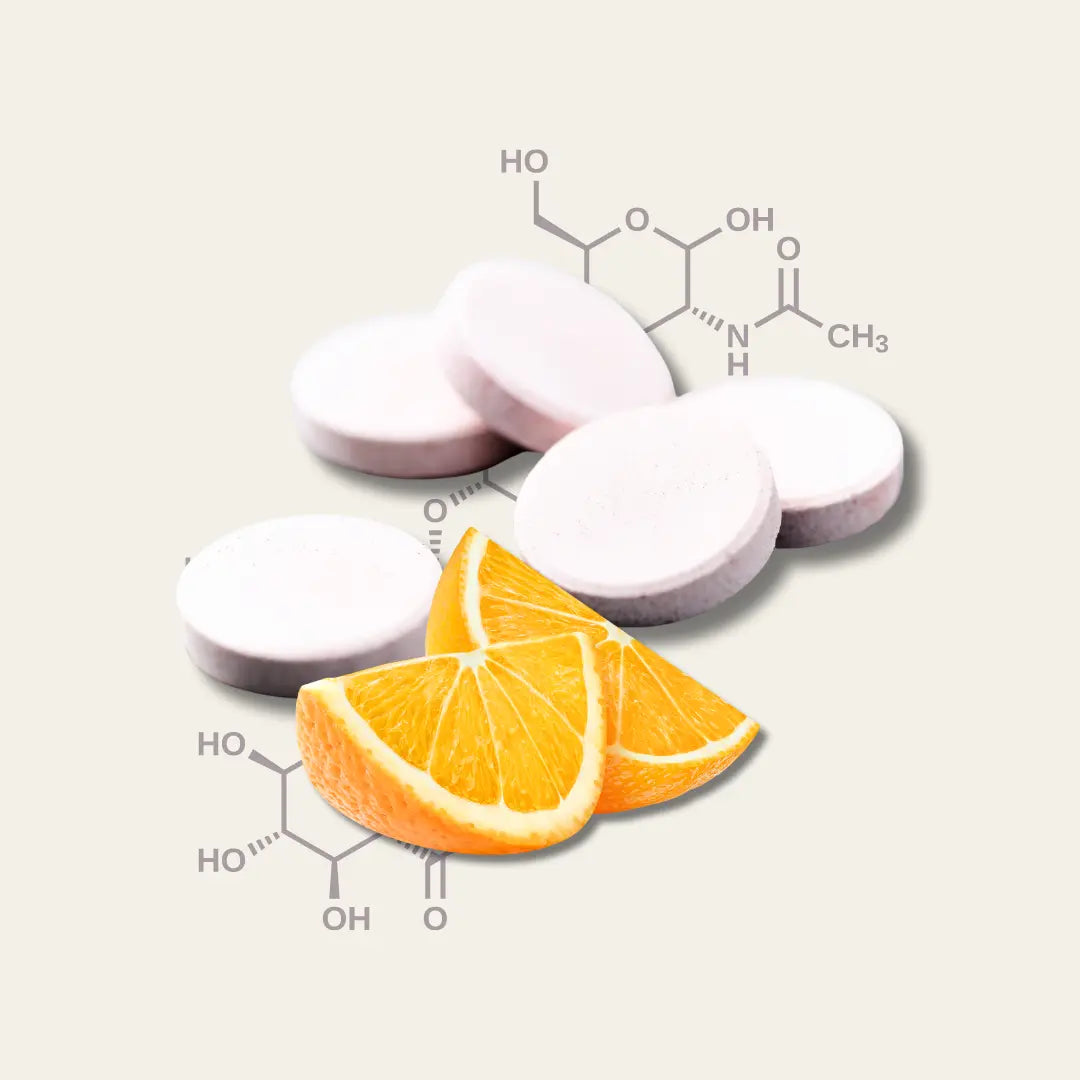 Fünf weiße Tablettenpresslinge und zwei Orangenscheiben