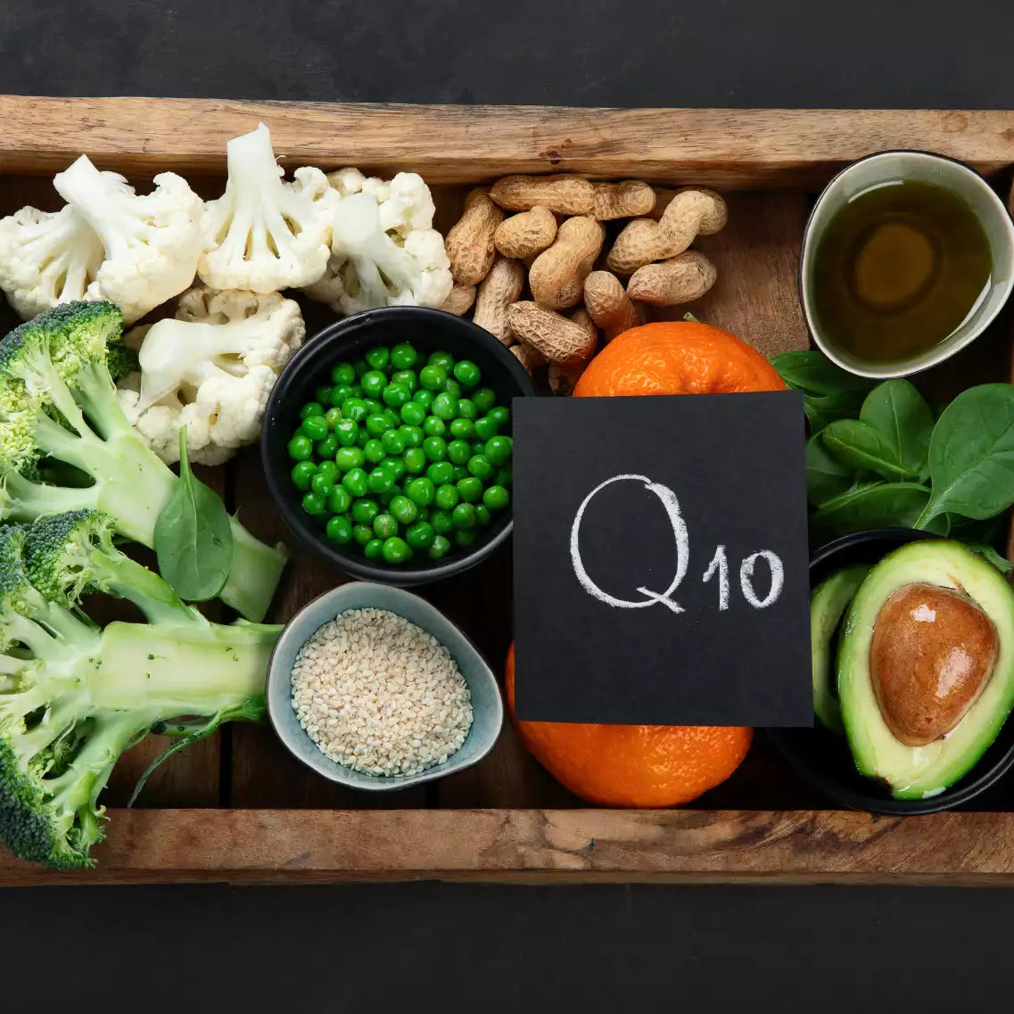 Holzkiste gefüllt mit Gemüse, Hülsenfrüchten und Früchten mit "Q10" Schild