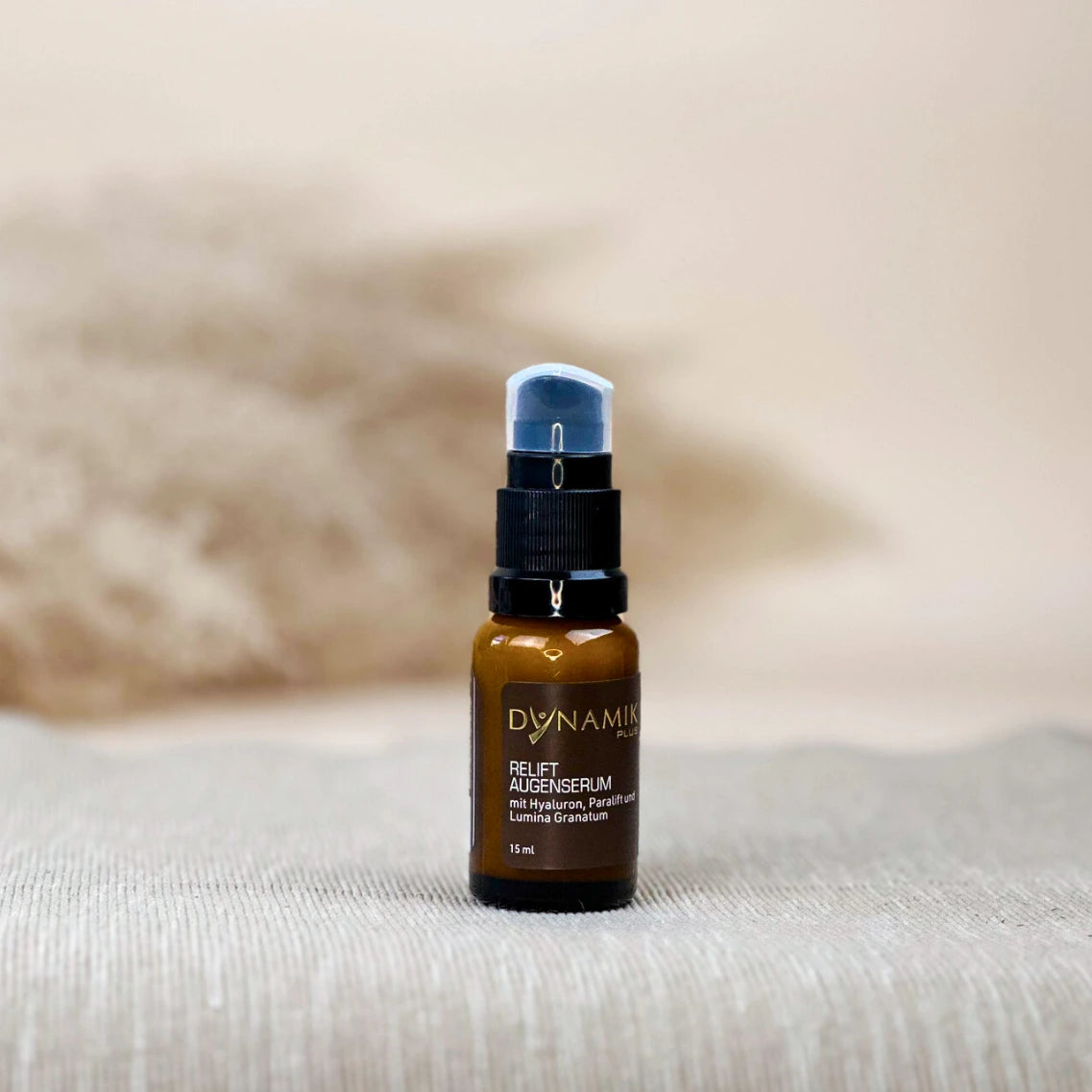 Braunes Fläschchen mit schwarzem Spenderkopf und DynamikPlus "Relift Augenserum" Etikett