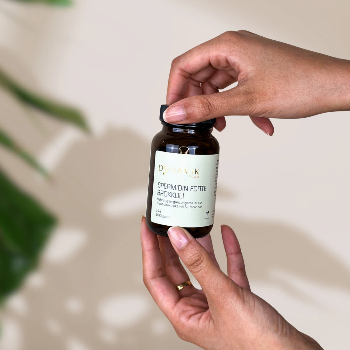 Brauner Glasbehälter mit DynamikPlus "Spermidin Forte Brokkoli" Etikett und schwarzem Drehverschluss