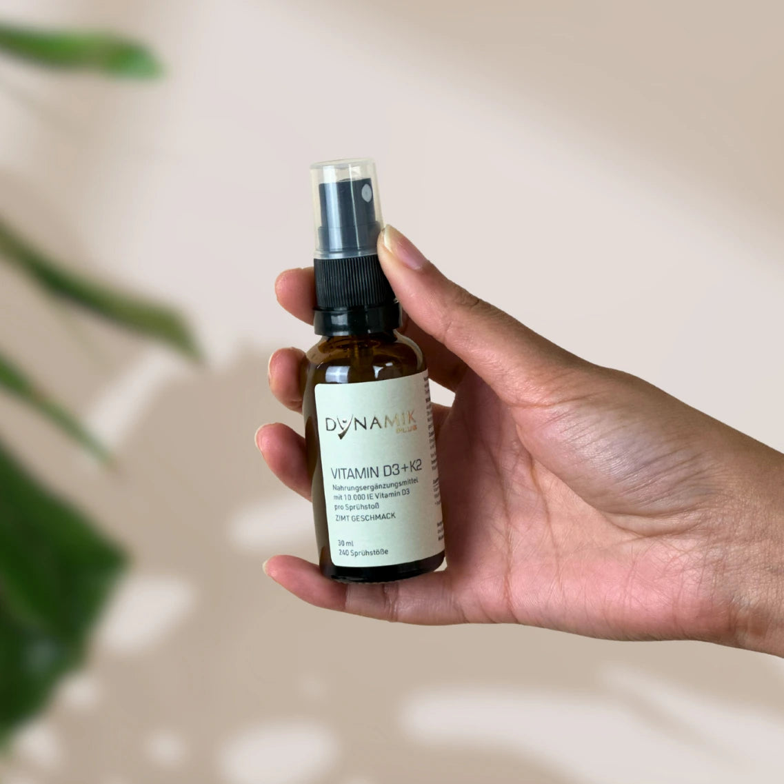 Braune Flasche mit Sprühkopf und DynamikPlus "Vitamin D3 + K2 - ZIMT Geschmack" Etikett auf der Flasche