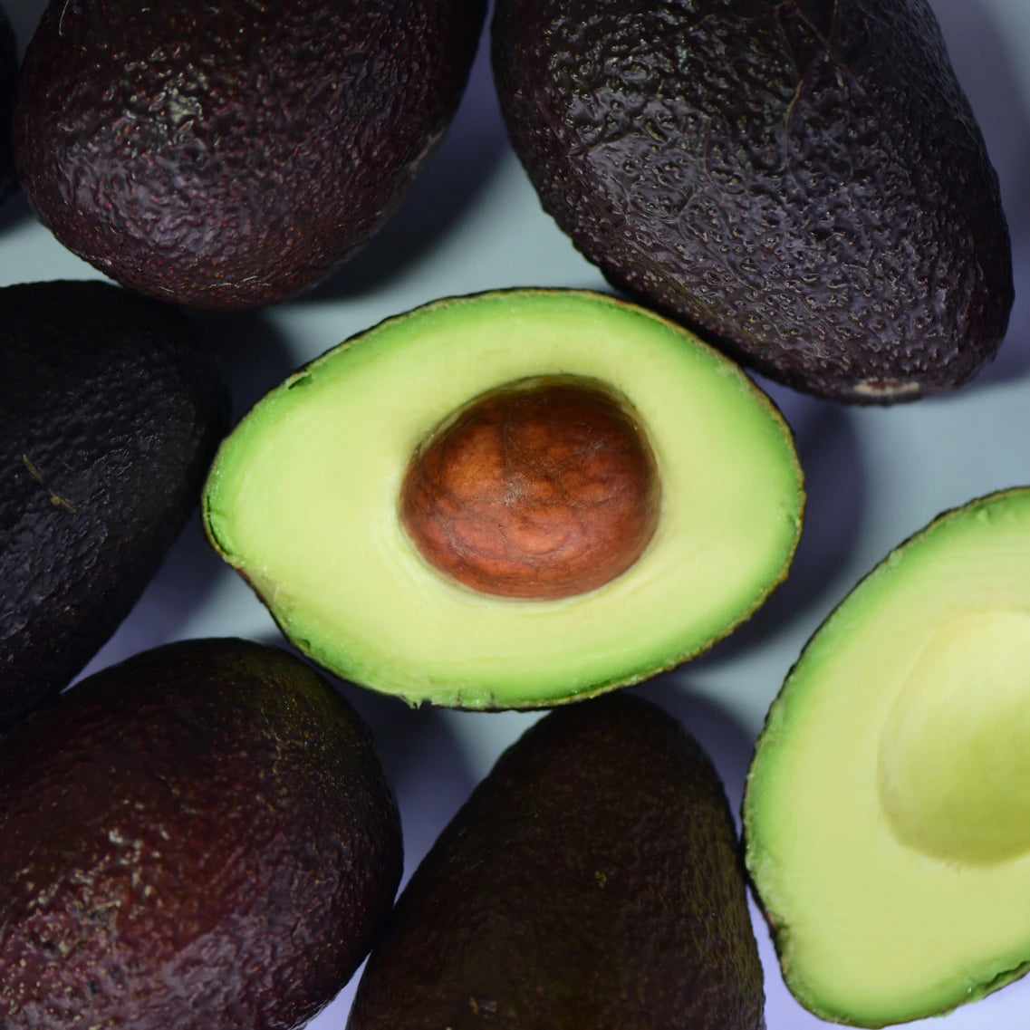 Avocados mit aufgeschnittener Avocado in der Mitte