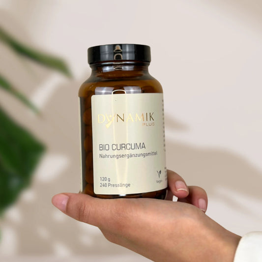 Brauner Glasbehälter mit DynamikPlus "Bio Curcuma" Etikett und schwarzem Drehverschluss