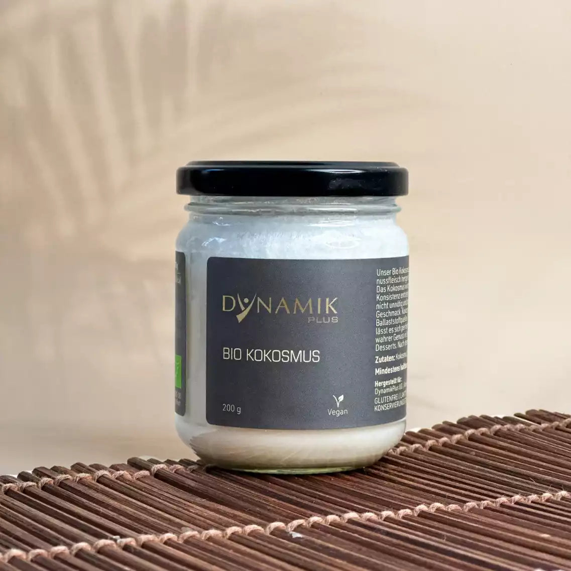 Weißer Glasbehälter mit DynamikPlus "Bio Kokosmus" Etikett und schwarzem Drehverschluss
