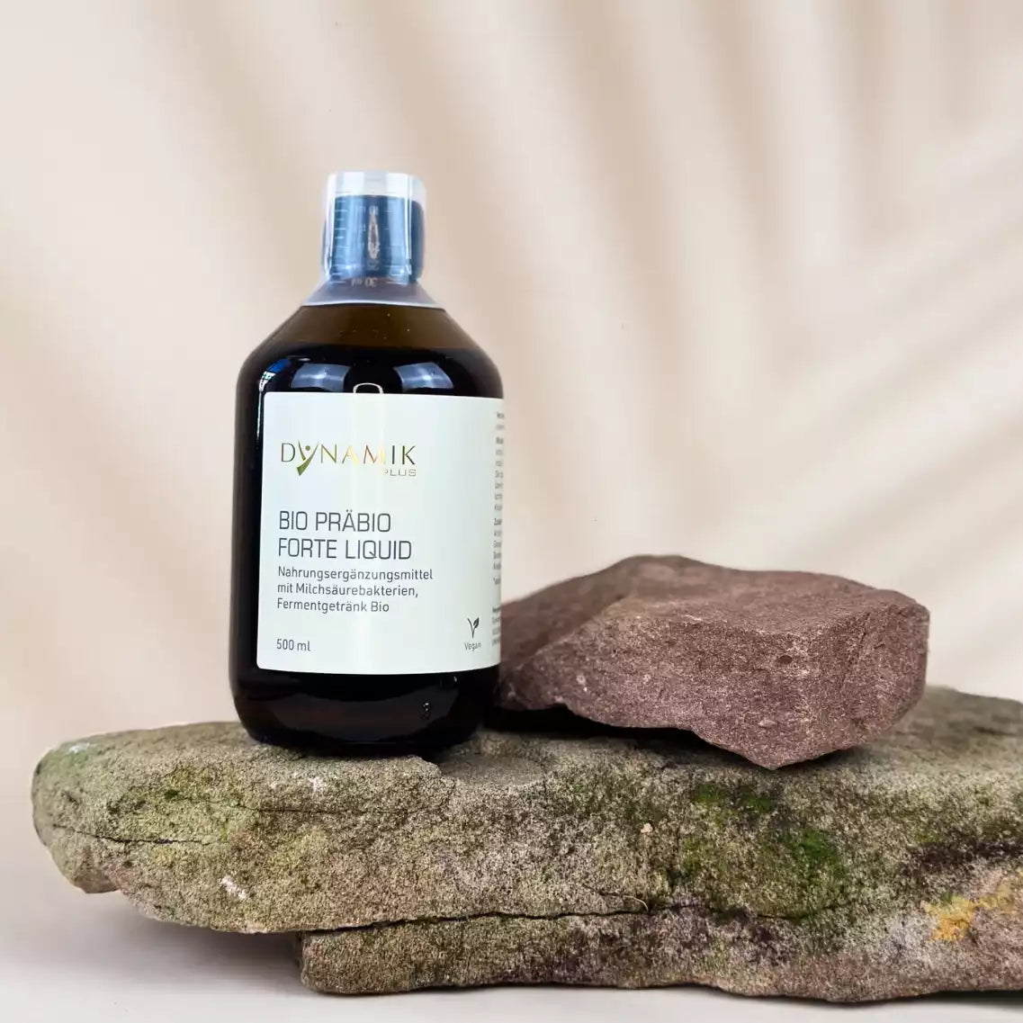 Braune Flasche mit DynamikPlus "Bio Präbio Forte Liquid" Etikett und kleinem Messbecher auf Verschluss