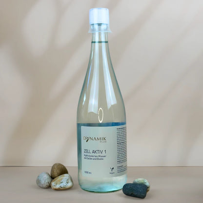 Glasflasche mit weißem Deckel, kleinem Messbecher und DynamikPlus "Zell Aktiv 1" Etikett